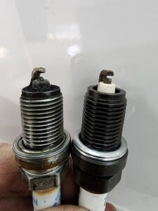 Show worn vs new spark plugs. Spark plug replacement. A worn spark plug on the left. A new spark plug on the right. Spark plug replacement